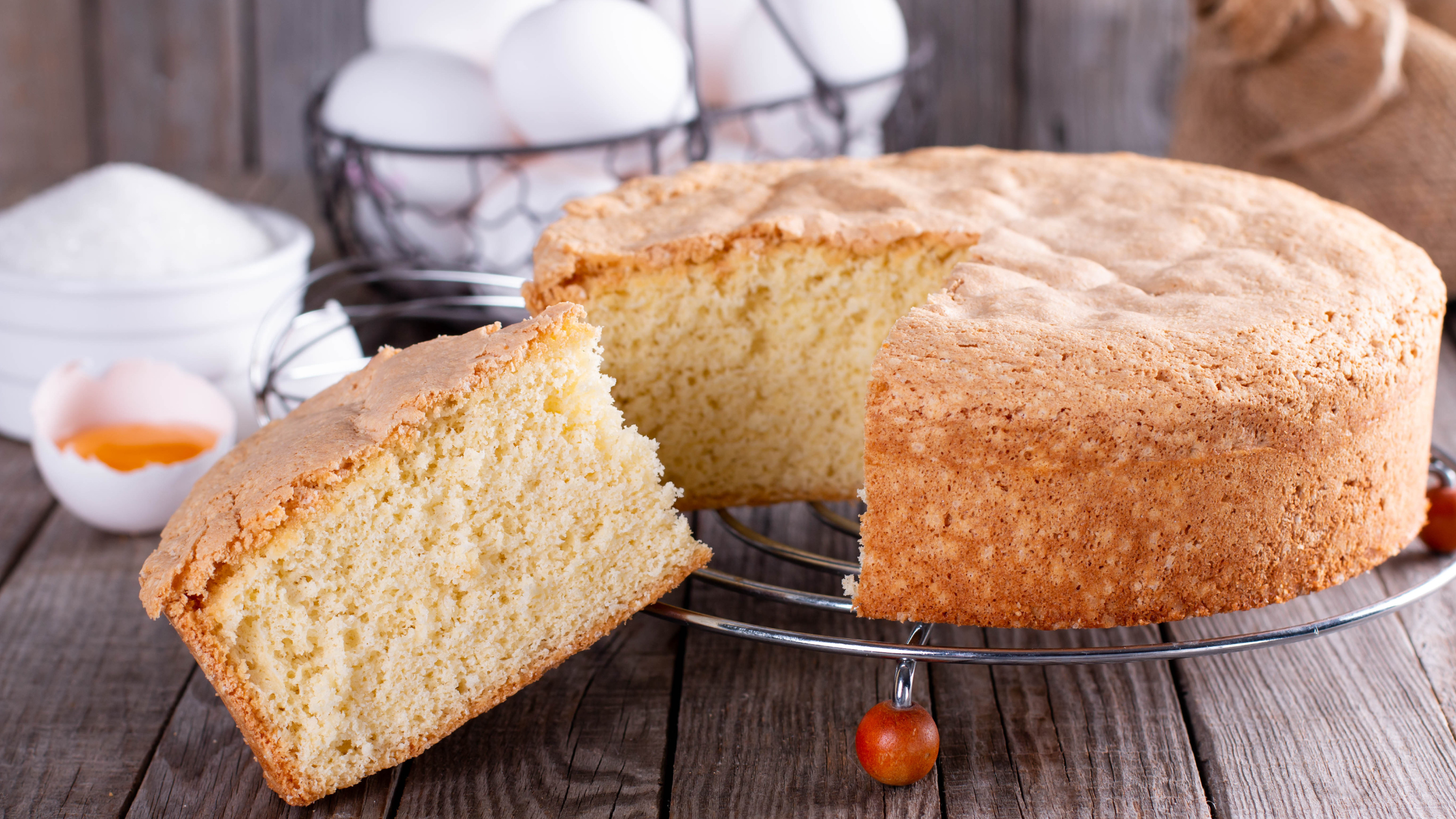 plain cake on cake stand with eggs in background